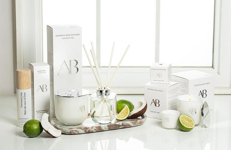 Aromatherapy products including diffusers, candles, and boxes on a white surface with a window in the background.