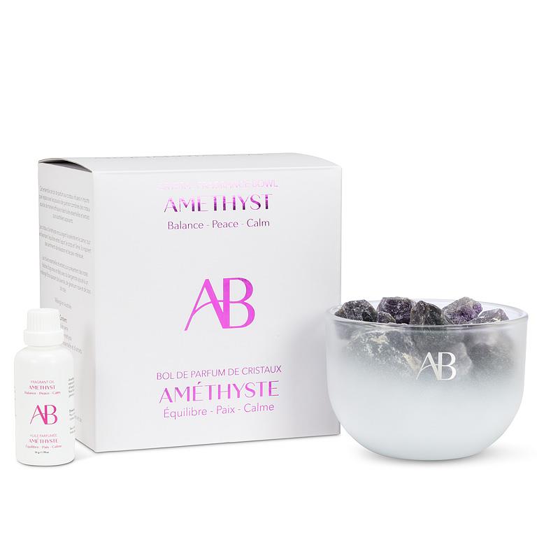 Amethyst crystal bowl with packaging and bottle on a white background