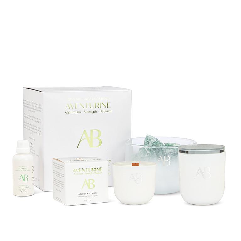 Aventusine skincare products including a box, bottle, and two candles on a white background.