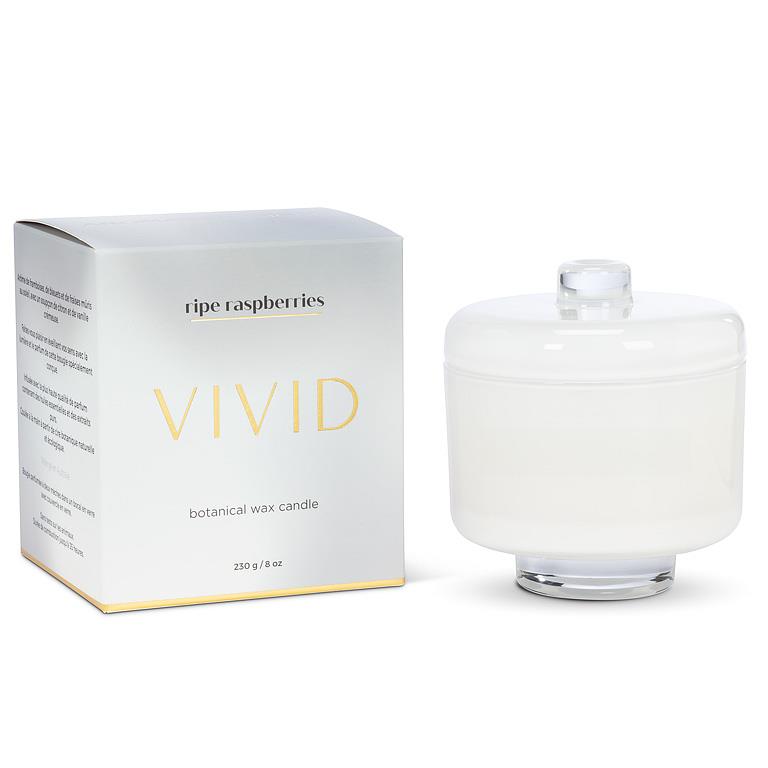 White candle with a clear lid next to its packaging on a white background