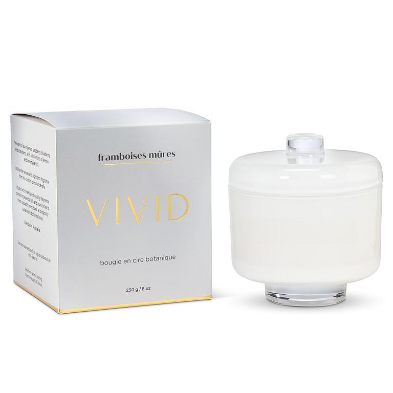 White candle with a lid next to its packaging on a white background