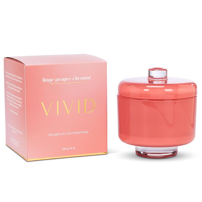 Coral-colored candle with a matching box on a white background