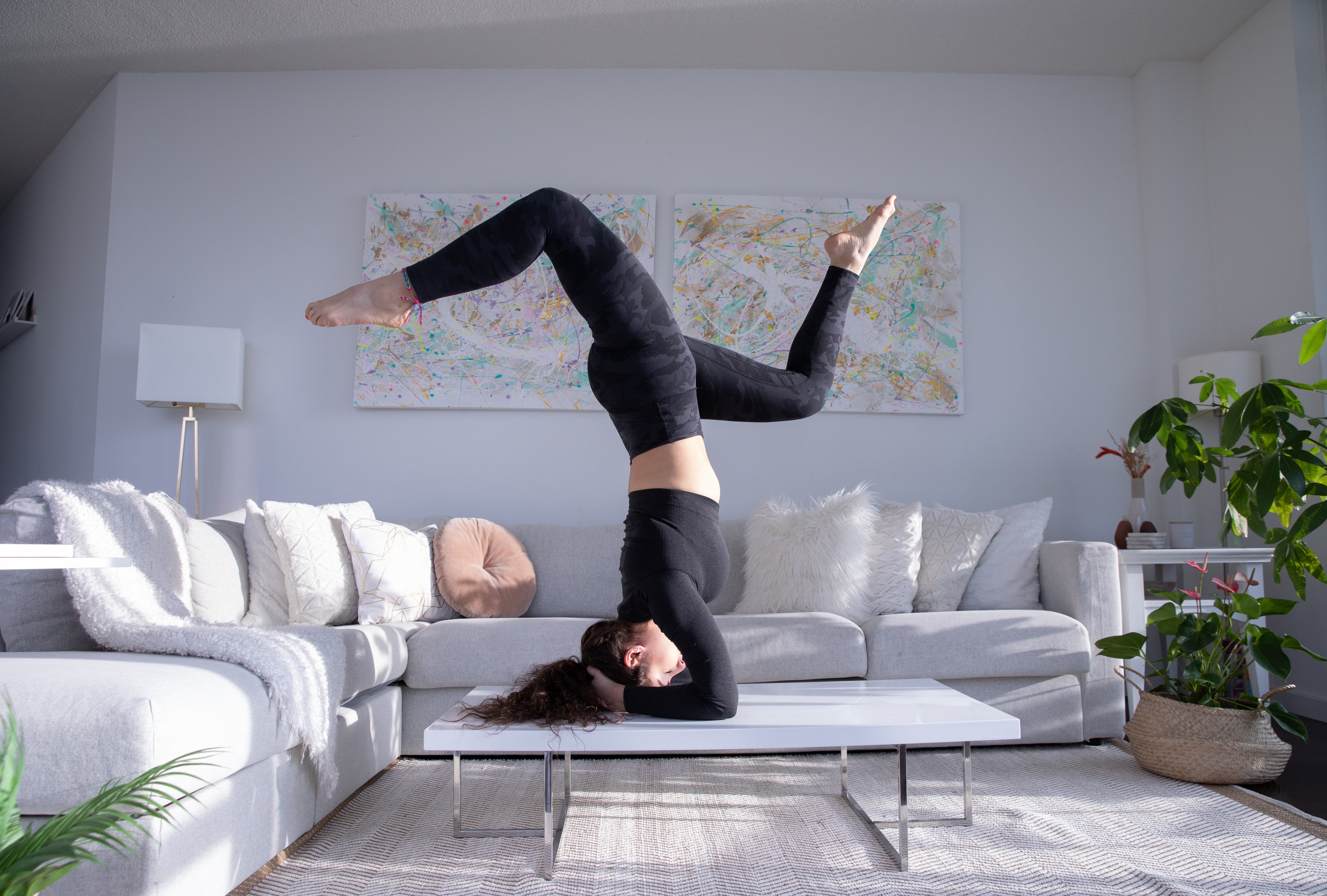 lady practicing yoga on their living room table.