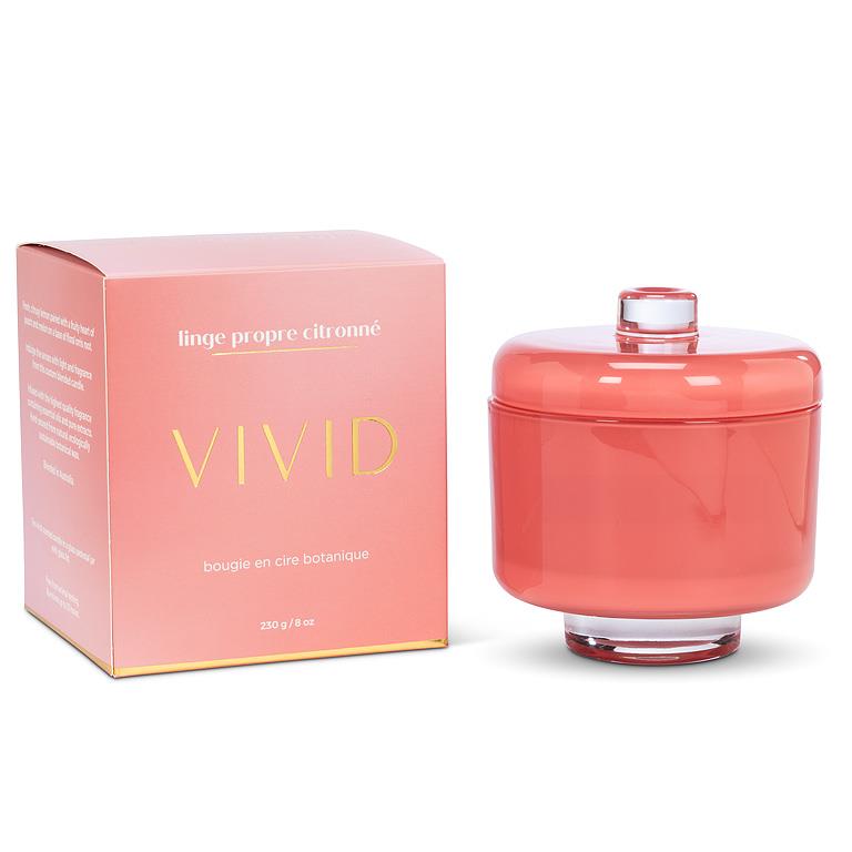 Coral-colored candle with matching packaging on a white background